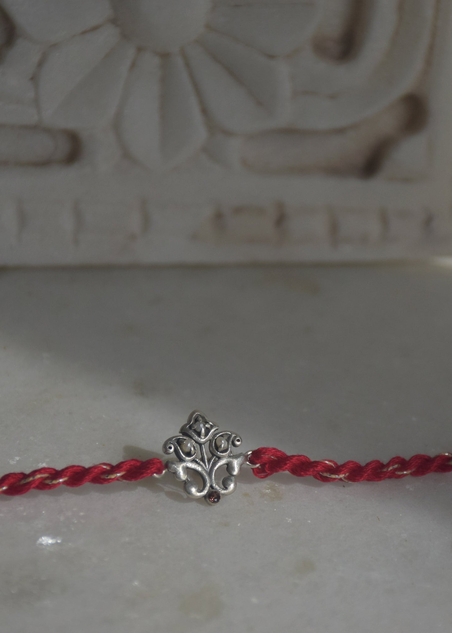 92.5 sterling silver Rakhi featuring real freshwater pearls and cotton thread.
