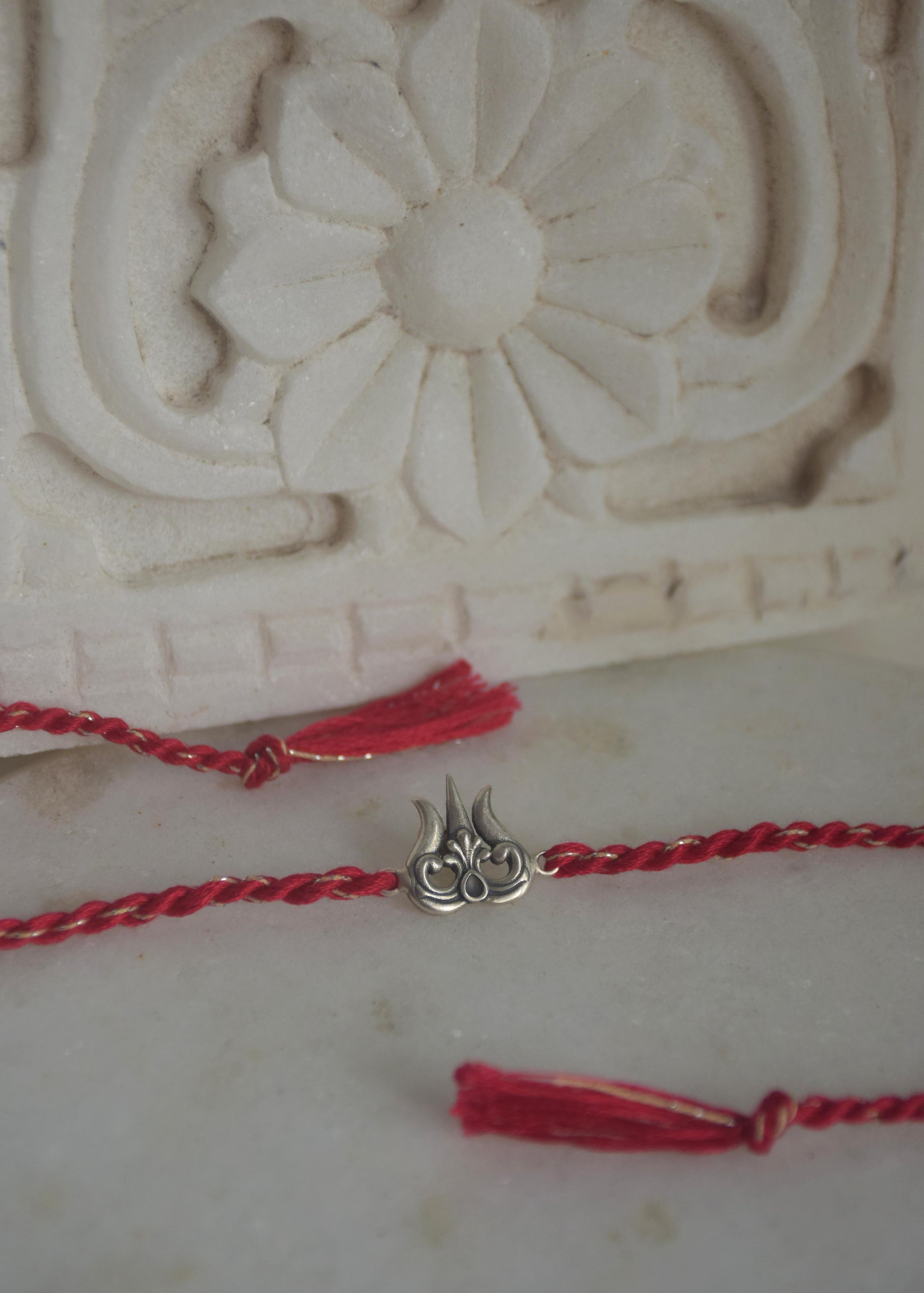 Elegant 92.5 sterling silver Rakhi for Raksha Bandhan, handcrafted with cotton thread and premium silver.