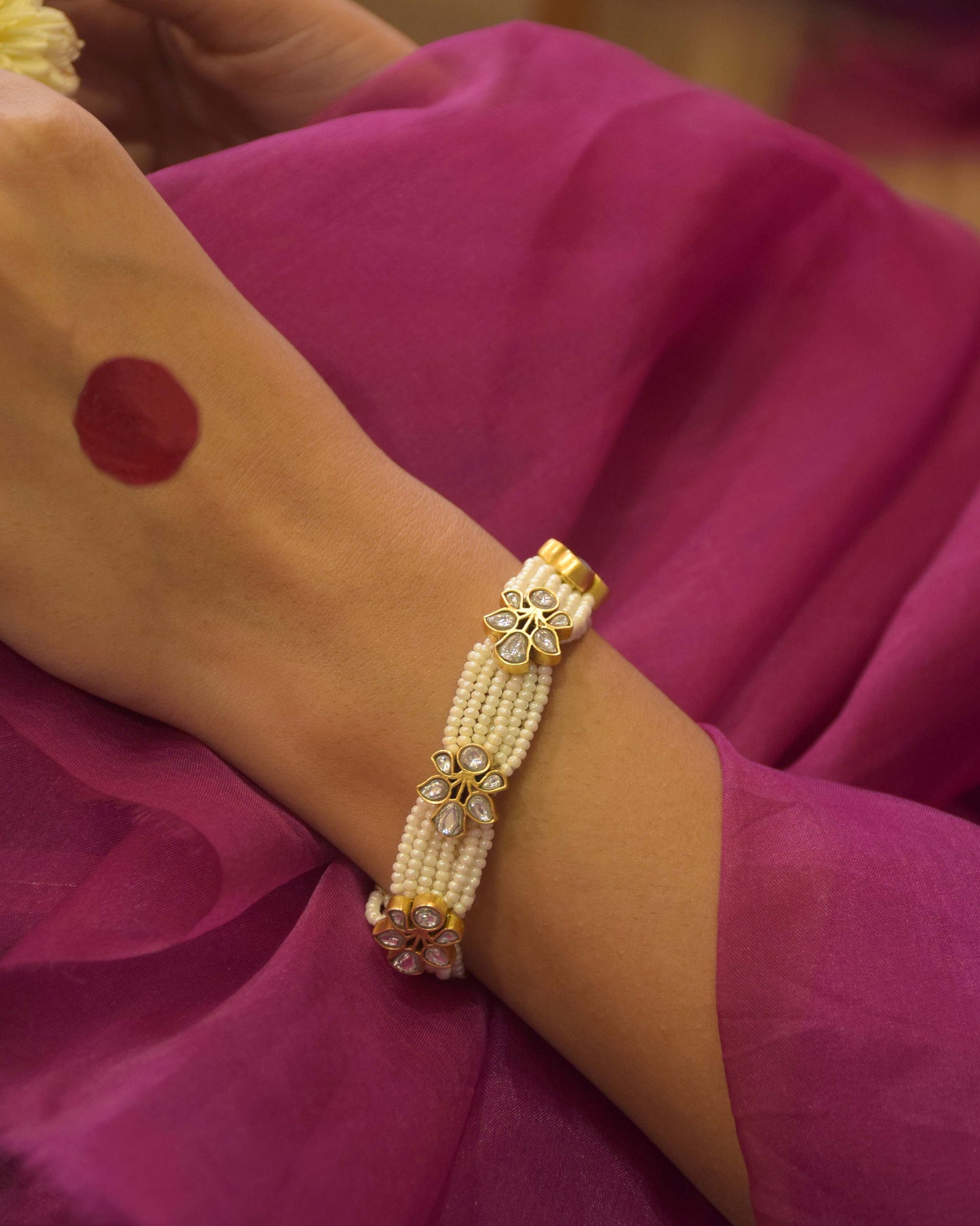Jogini Bracelet handcrafted in 925 silver, featuring elaborate floral motifs embellished with white Jadau stones and finished with delicate seed pearl piroi.