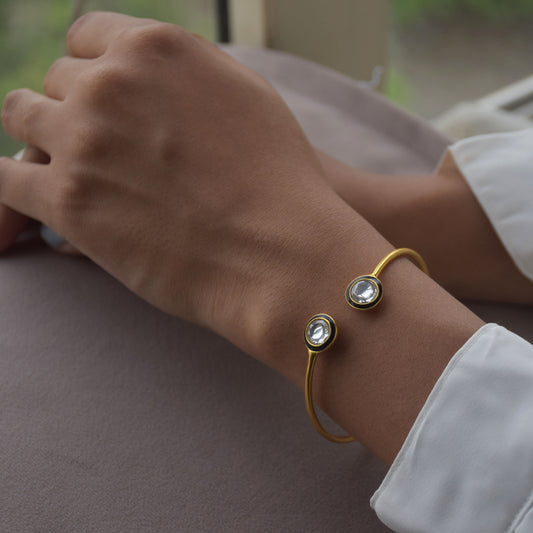 Kaira Adjustable Bangle crafted in gold-plated 92.5 silver, featuring two dazzling Belure Polki stones framed by intricate black Meena work.