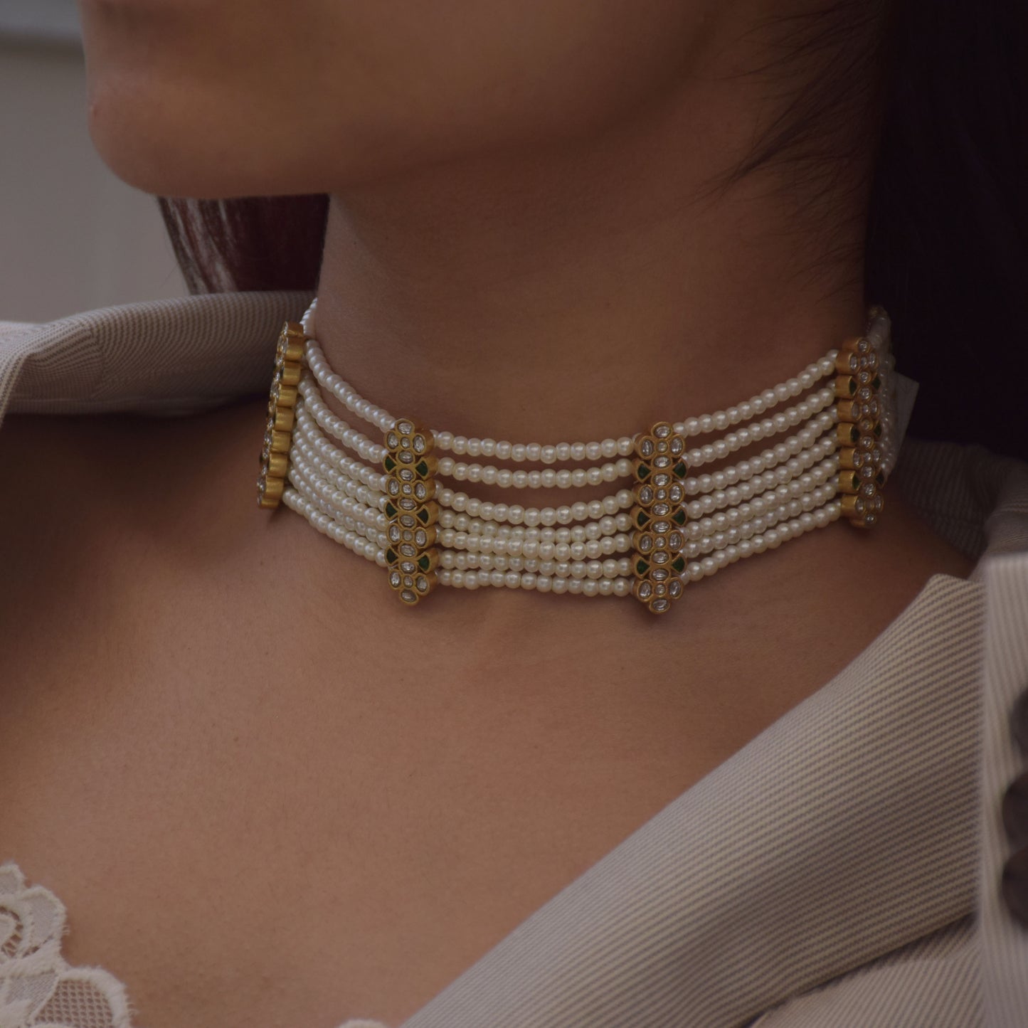 Raatrani Choker crafted in 925 silver featuring five vertical units with Jadau stone-studded flower motifs and seven strands of lustrous shell pearls.