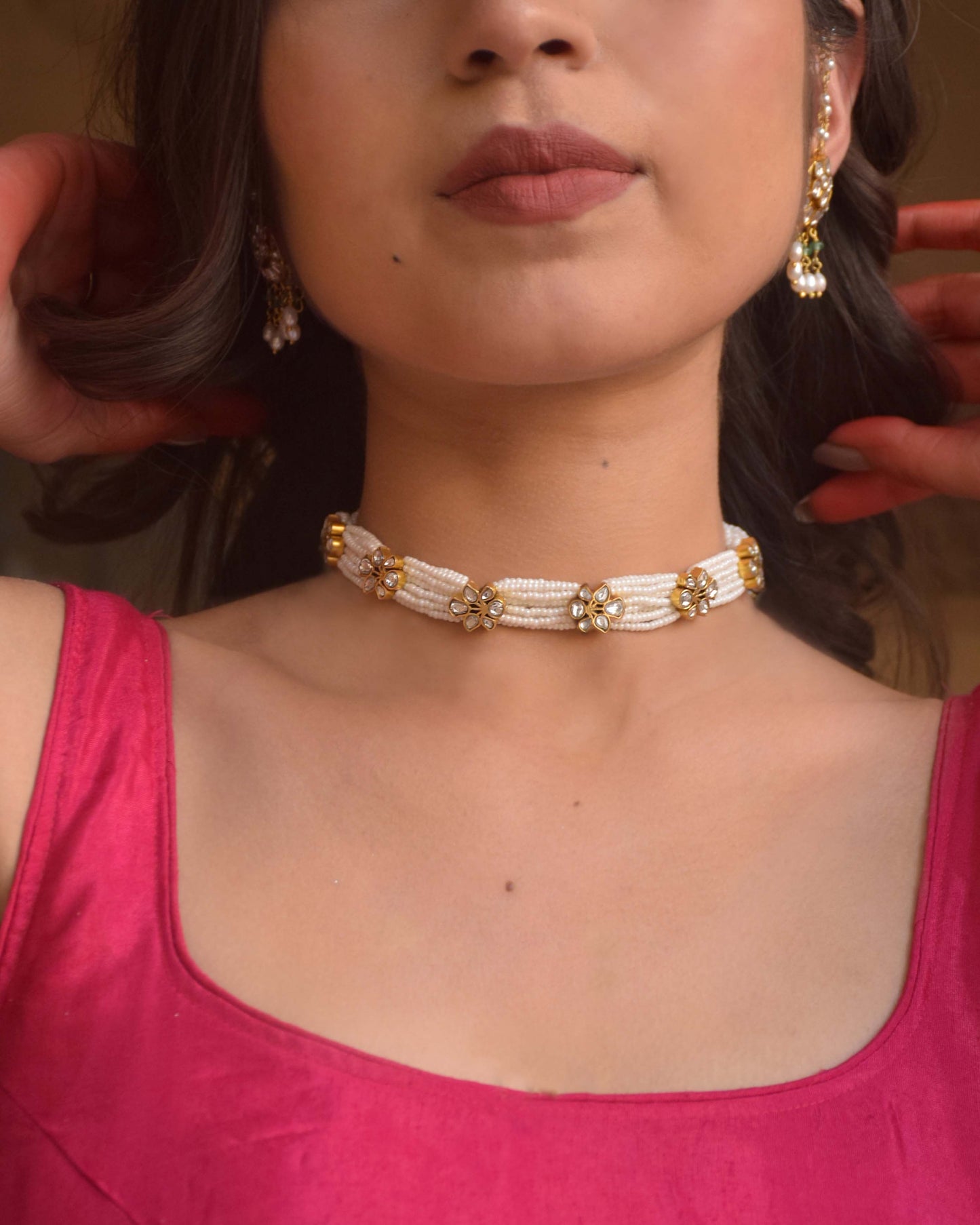 Premika Choker crafted in 925 silver, featuring floral motifs studded with white jadau stones and intricately intertwined guccha piroi design accented with delicate seed pearls.