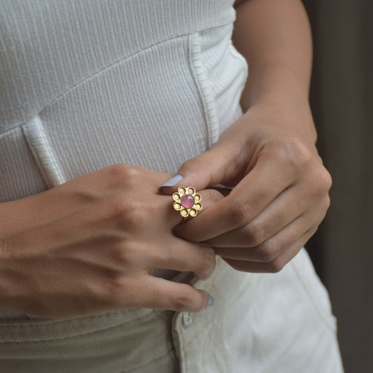 Gulabi Ring showcasing a beautiful rose quartz stone elegantly encased within a gold flower design.