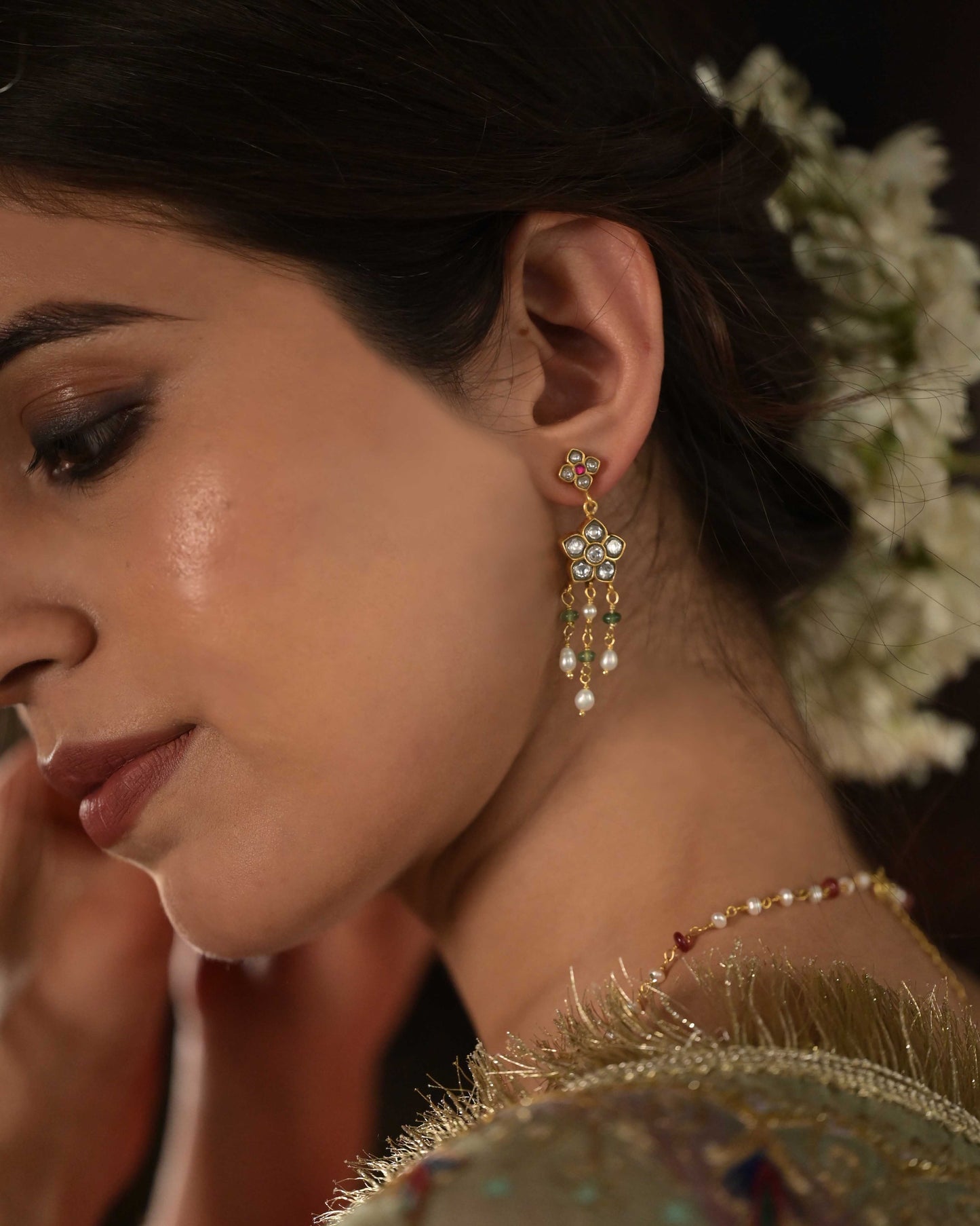 Avani Earrings crafted in 925 silver with gold polish, featuring delicate floral motifs adorned with jadau glass-filled stones, accented by drops of rice pearls and green aventurine beads
