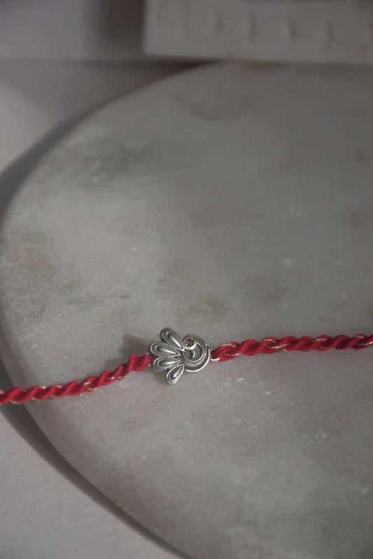 92.5 sterling silver Rakhi adorned with real freshwater pearls and cotton thread.