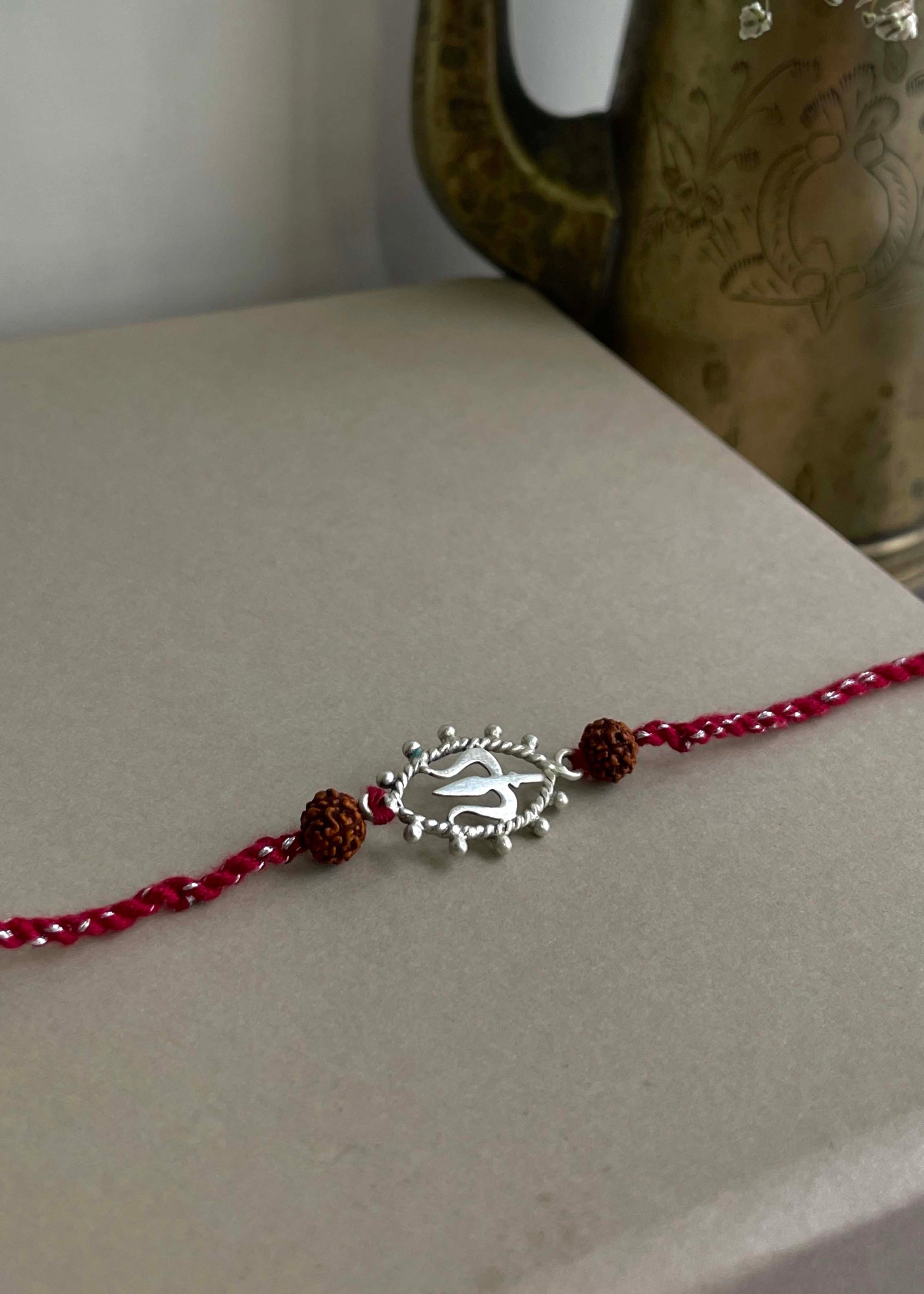 92.5 sterling silver Rakhi featuring real freshwater pearls and cotton thread,