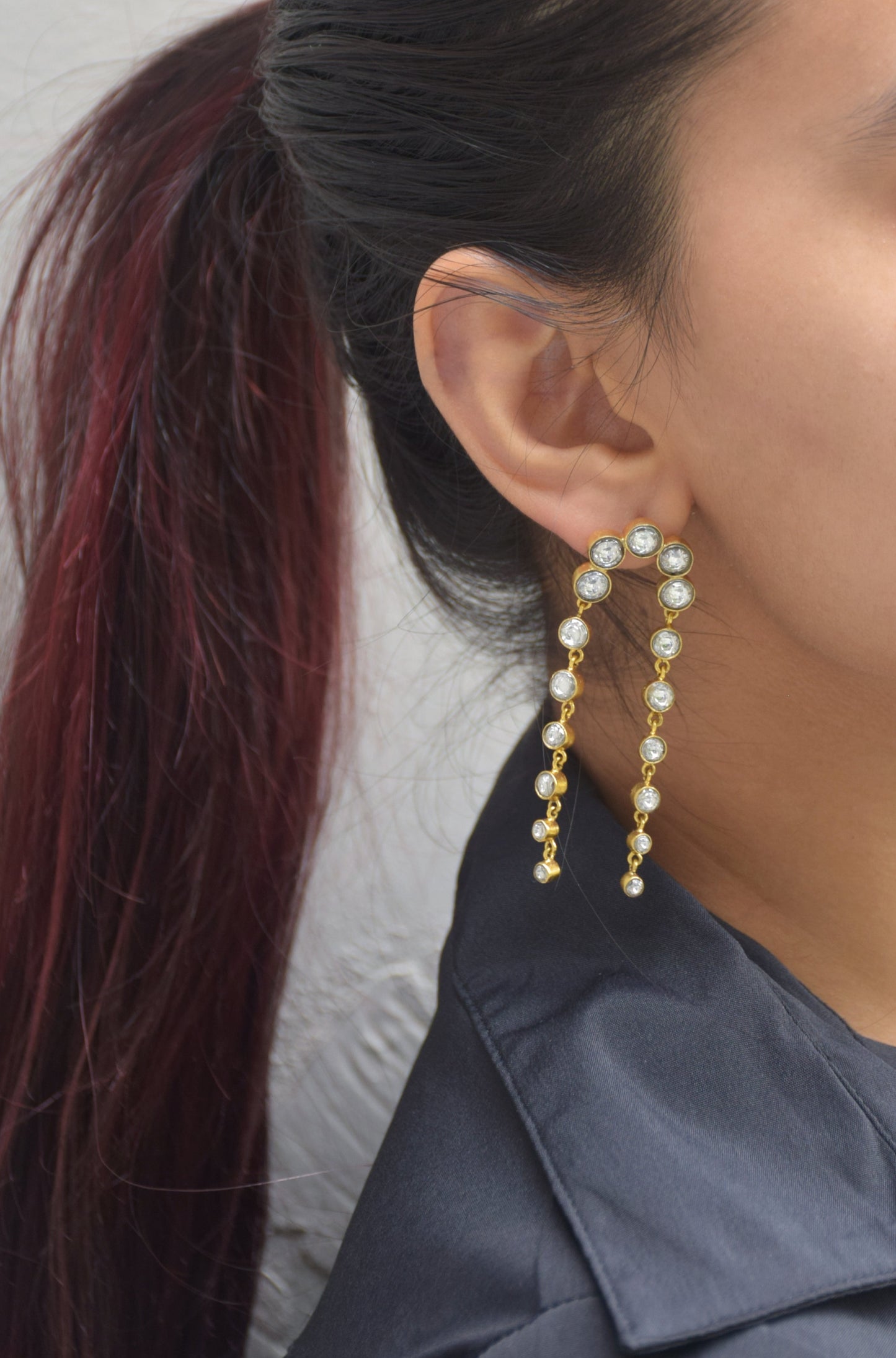 Tarangini Earrings crafted in 925 silver, featuring a flowing chain of Jadau stone collets that sway gracefully with every step.