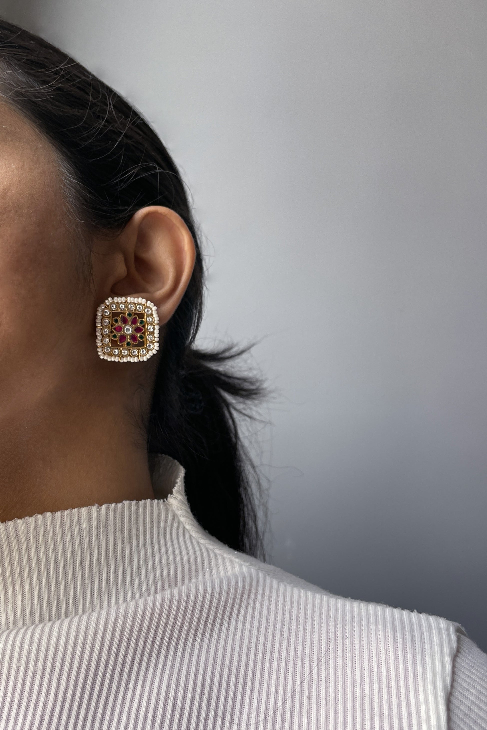 Aayat 925 silver square earstuds adorned with multicolored Jadau stones and bordered with delicate seed pearls.