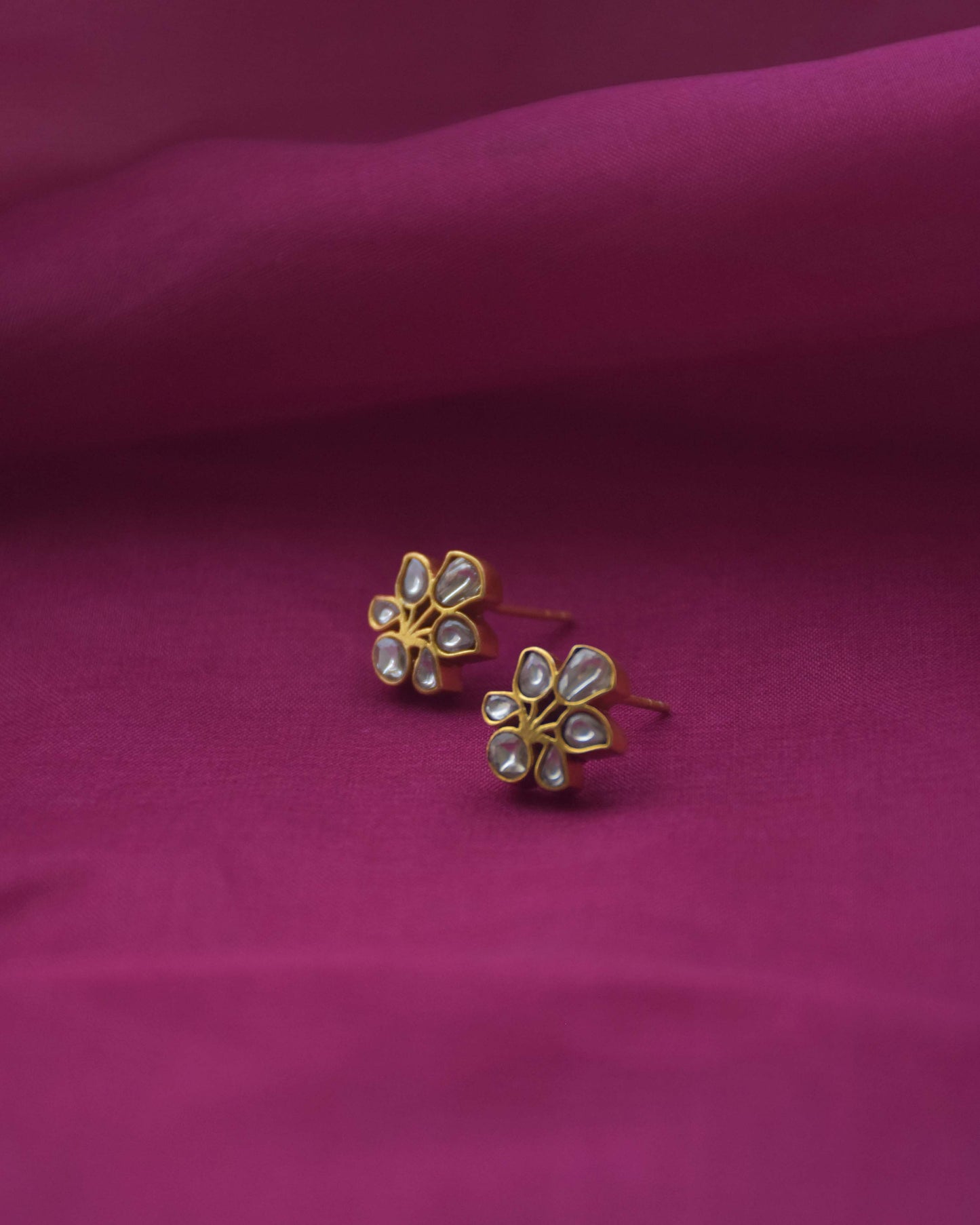 All-white Jadau floral stud earrings crafted from gold-polished 925 silver.