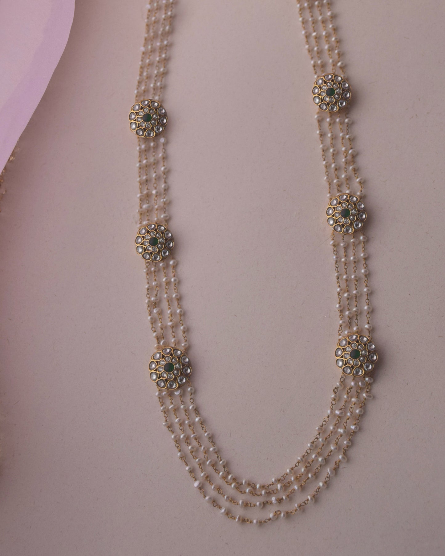 Anuradha Ranihaar necklace handcrafted in 925 silver with gold polish, featuring round Jadau-studded motifs on long pearl strands.