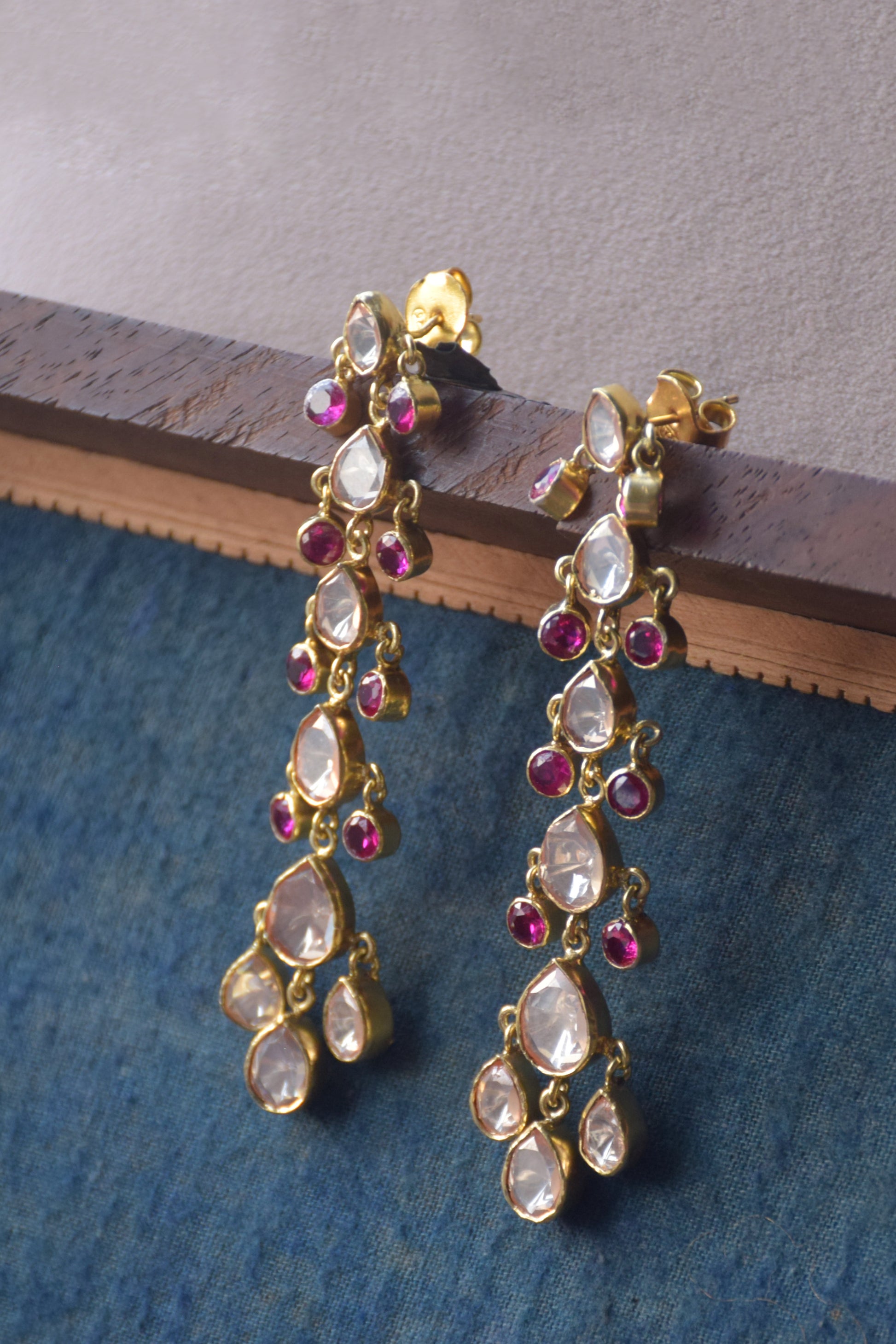 Boondan Polki Earrings featuring shiny Polki drops arranged in ascending order, accented with small pink AD stones that dangle elegantly. Crafted for graceful movement and eye-catching style, these 925 silver statement earrings.