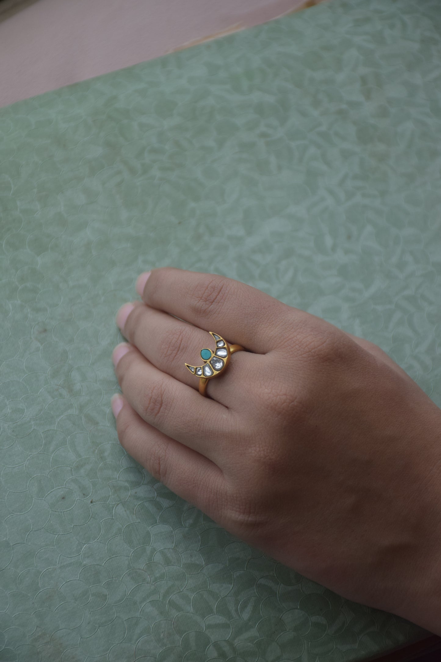 Chand Firoza ring crafted in 925 sterling silver with 22K gold plating, featuring a minimalist Jadau chand design adorned with white Jadau stones and a central Firoza stone.