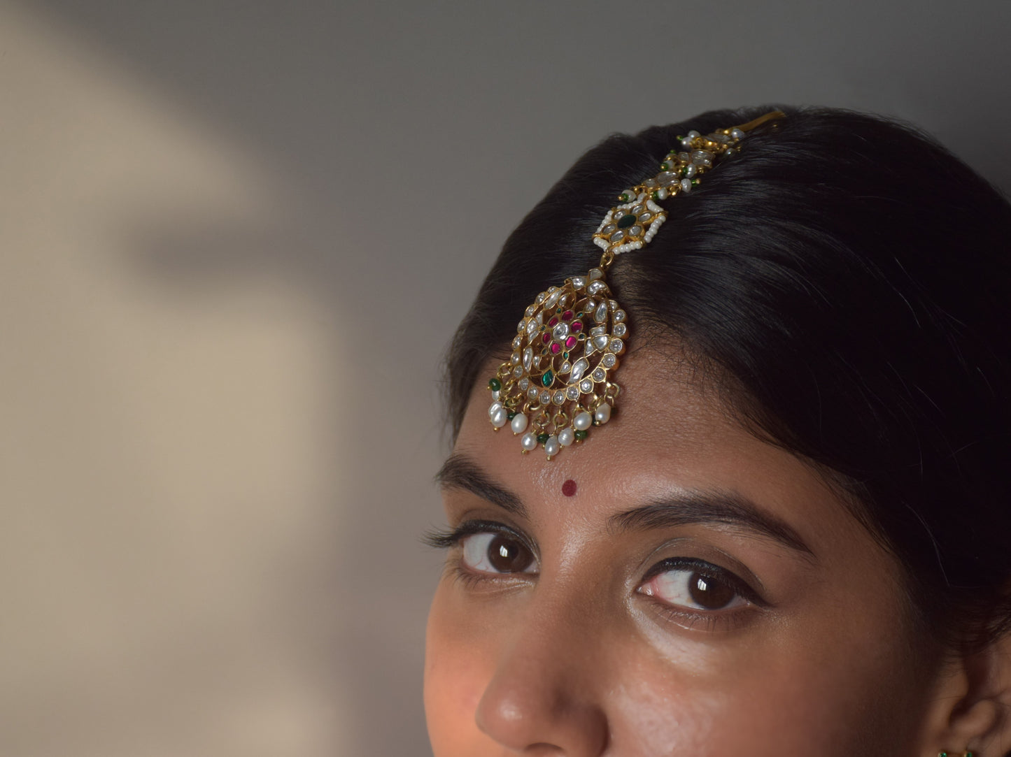 Luxury handcrafted maangtika in 925 silver featuring intricate green, pink, and white Jadau stones with pearl strands.premium 925 sterling silver jewelry