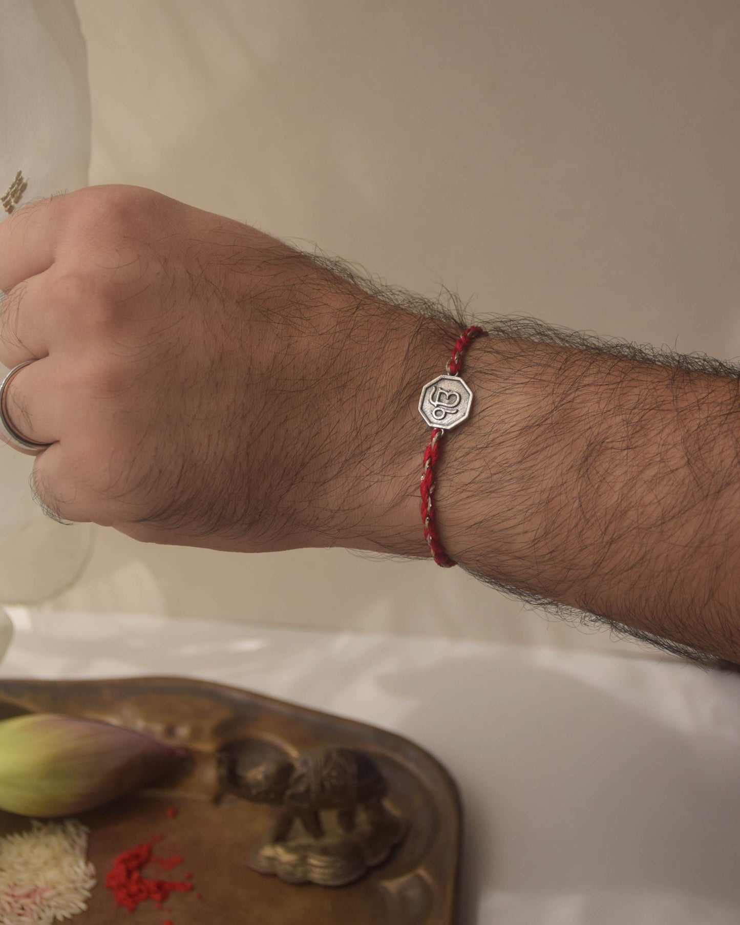 Ek Onkar rakhi in 925 sterling silver with red cotton thread. Comes with complimentary Kumkum & Chawal.