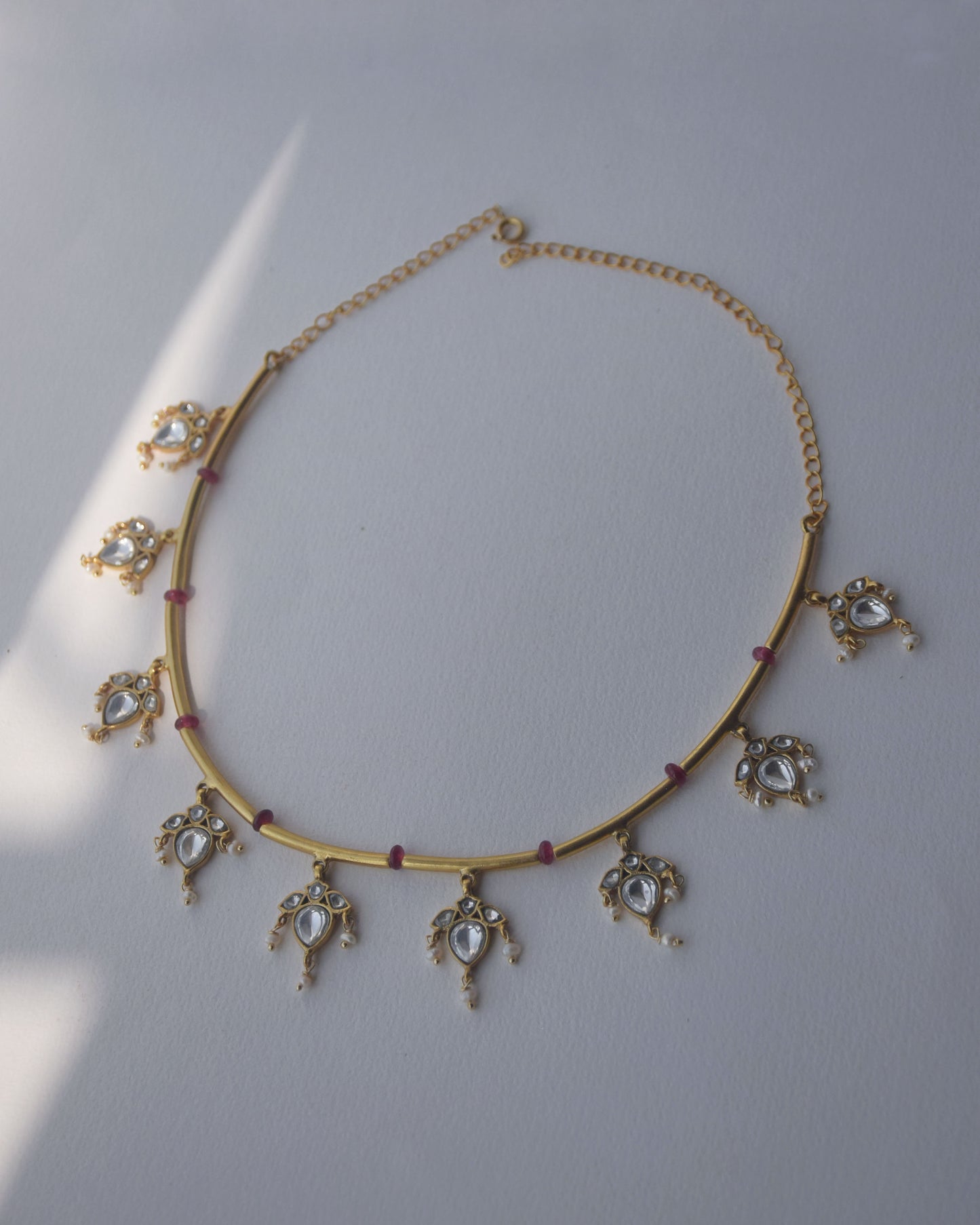 Contemporary hasli design featuring pink beads, floral motifs, and cascading freshwater pearls in gold finish.