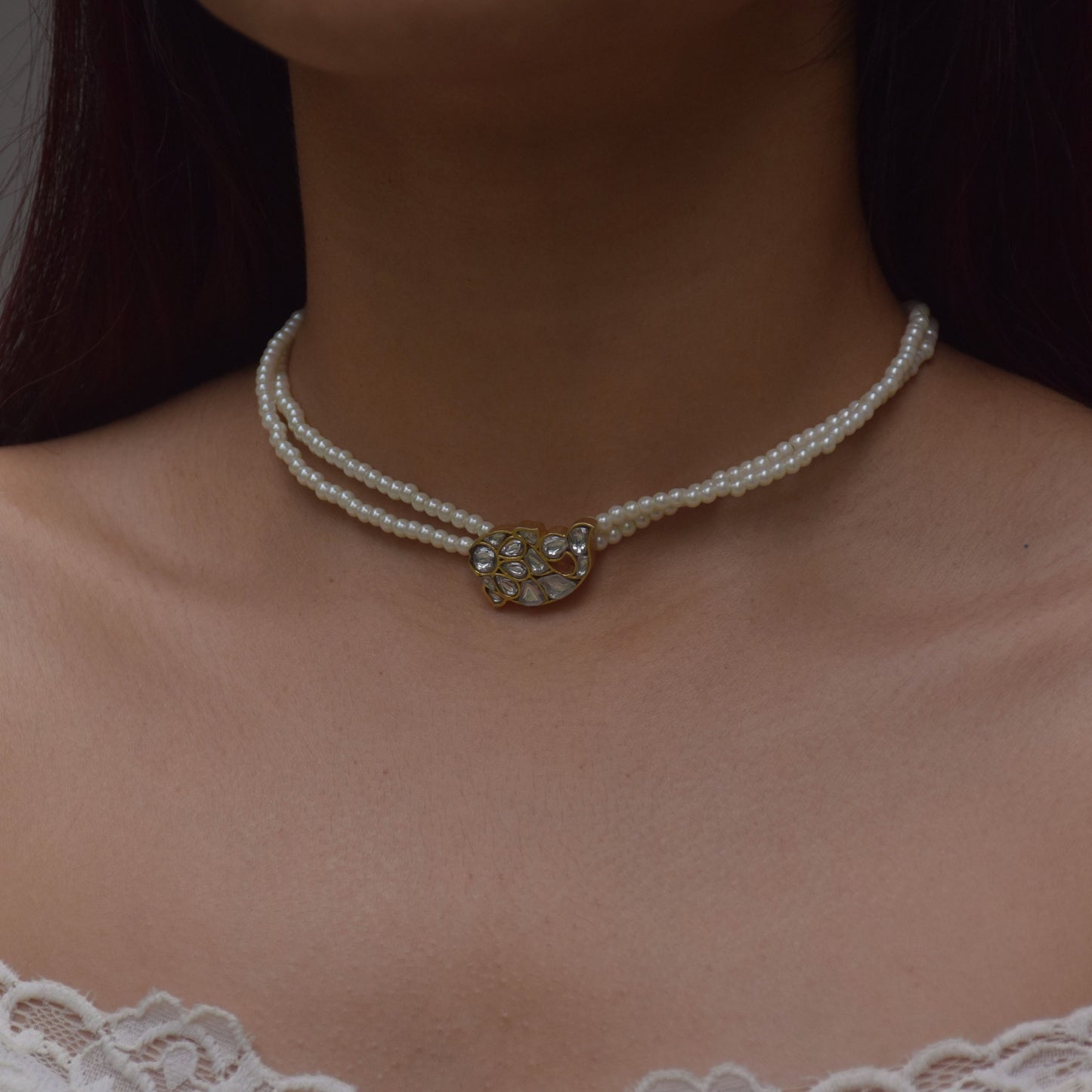 "Nuvi Matsya Necklace in 925 silver featuring an intricately crafted fish motif adorned with white jadau stones, framed by delicate lines of lustrous shell pearls.
