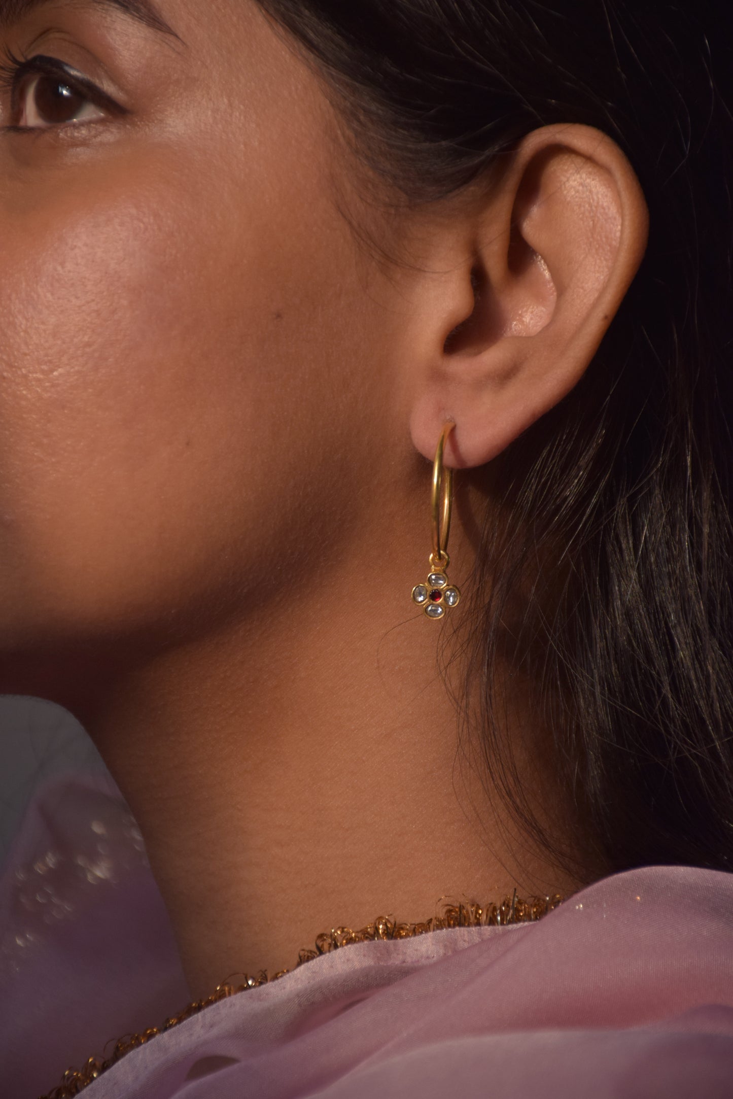 Raatrani Hoop Earrings crafted from 925 silver with 22-carat gold plating, featuring a 4-petal Jadau stone-studded flower motif hanging from the hoop.