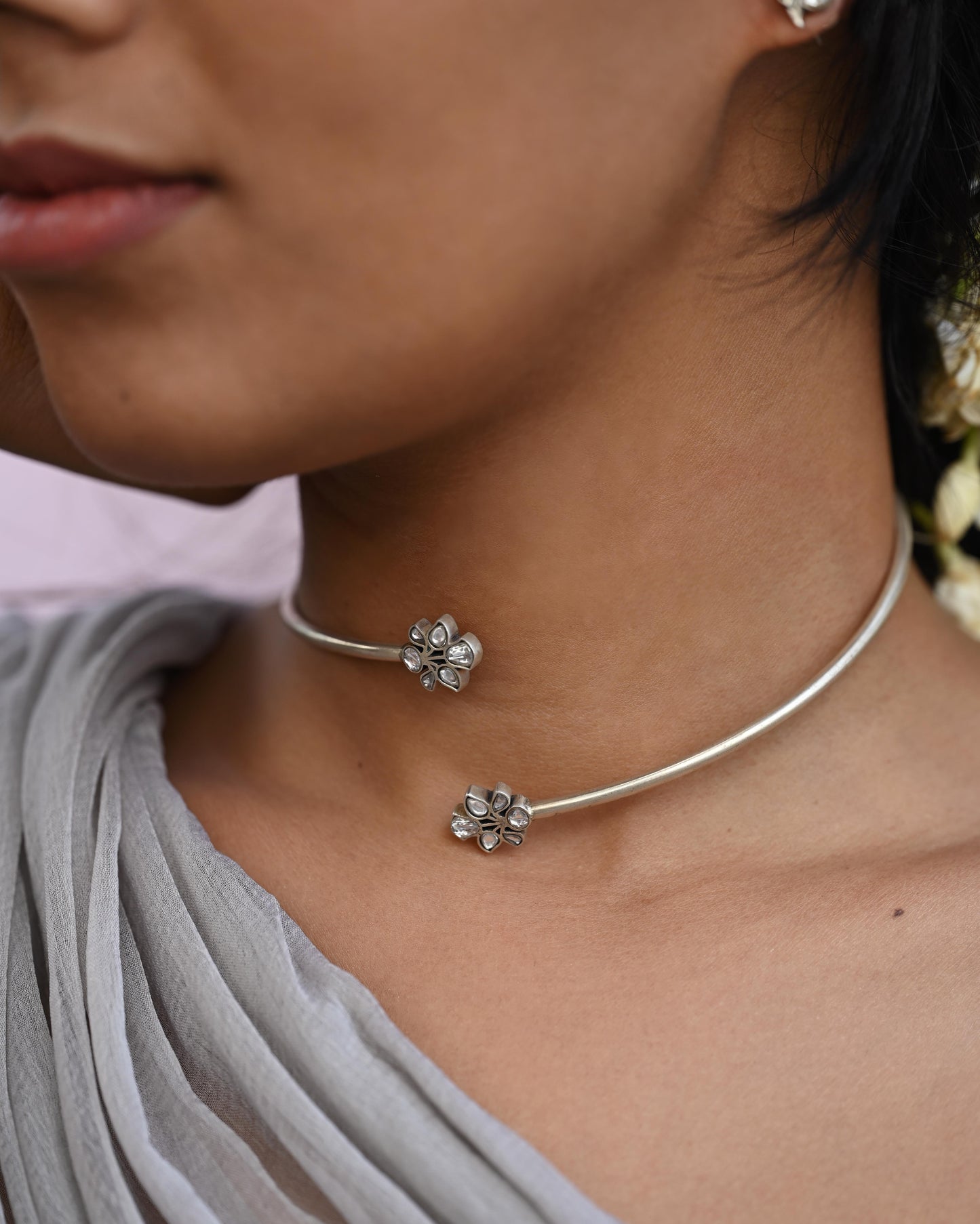 Rasini Hasli necklace handcrafted in 92.5 sterling silver, featuring twin floral motifs facing each other – elegant and versatile Indian jewelry inspired by traditional Hasli design.