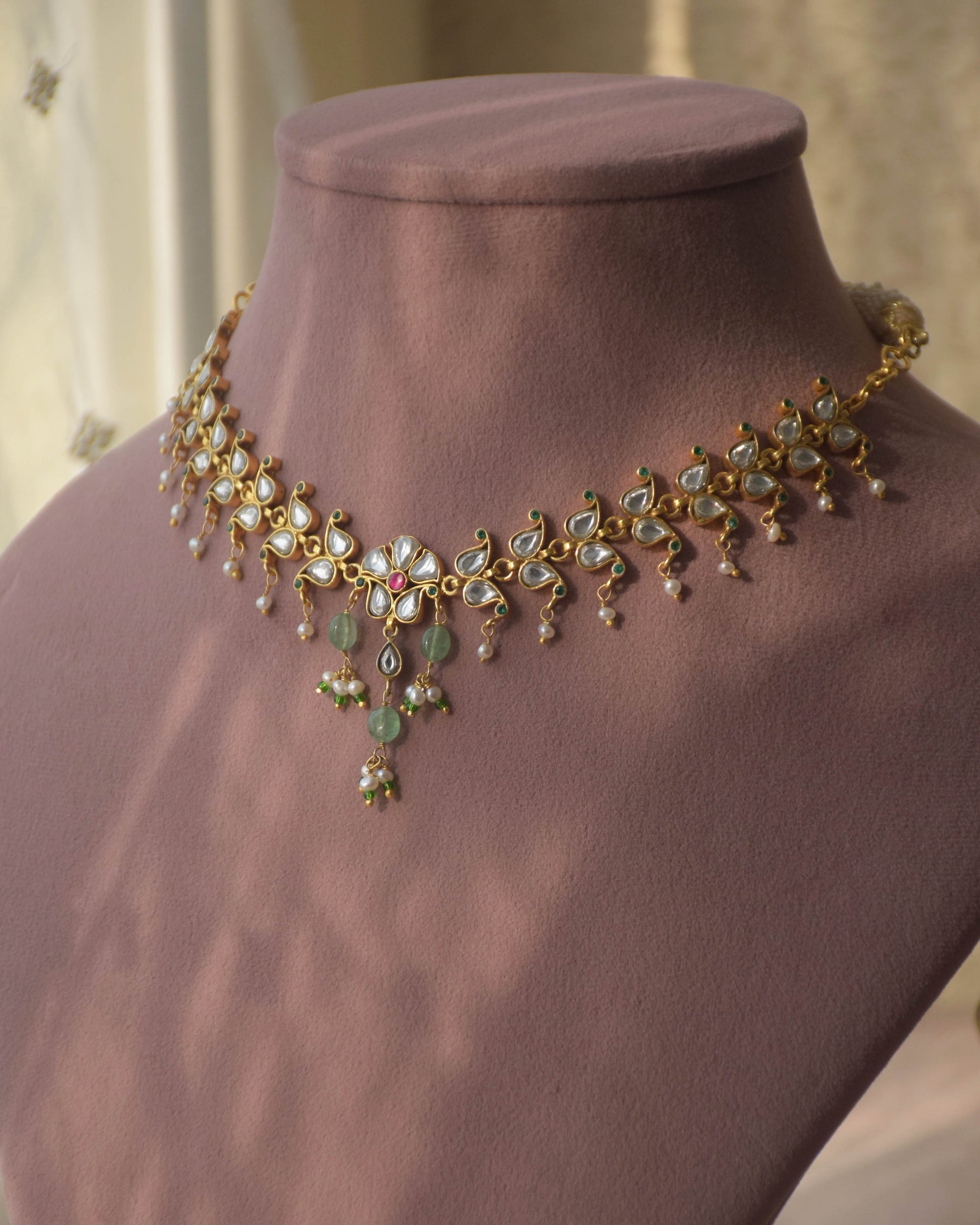 Vanya necklace handcrafted in 92.5 sterling silver, featuring intricate Jadau work and a flowing line of paisley motifs, elegantly finished with dangling pearl drops.
