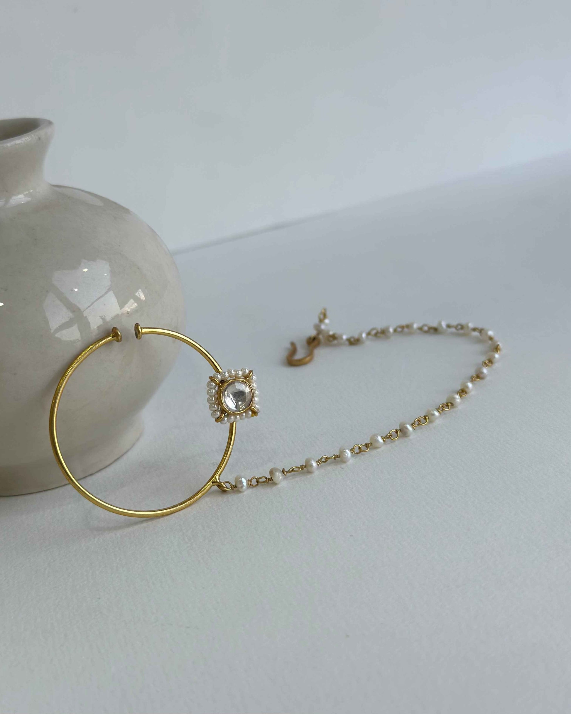 This nath/ nose ring is composed of pure 92.5 silver, gold plated and with pearl string.