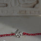  92.5 sterling silver Rakhi featuring real freshwater pearls and cotton thread.