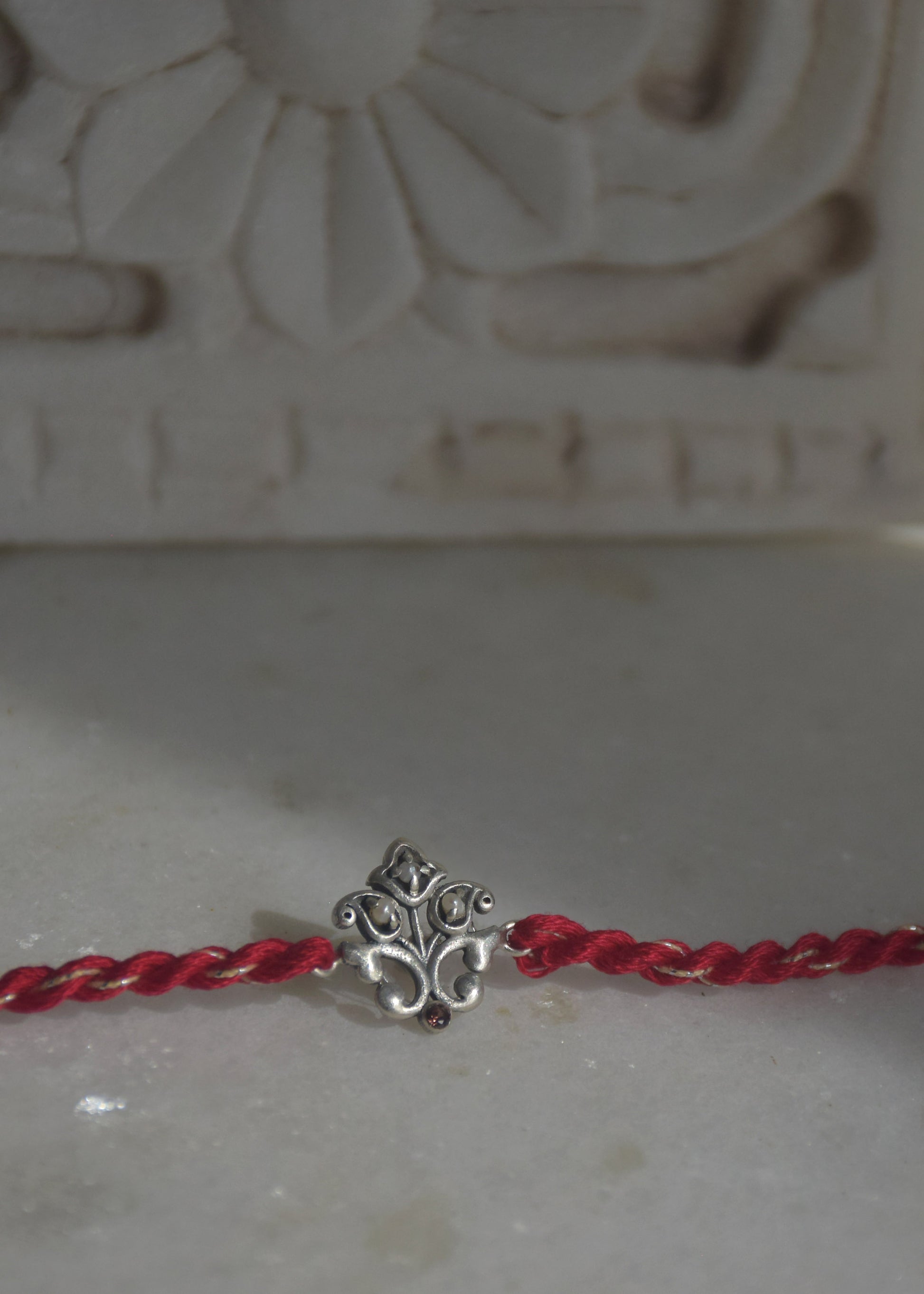  92.5 sterling silver Rakhi featuring real freshwater pearls and cotton thread.
