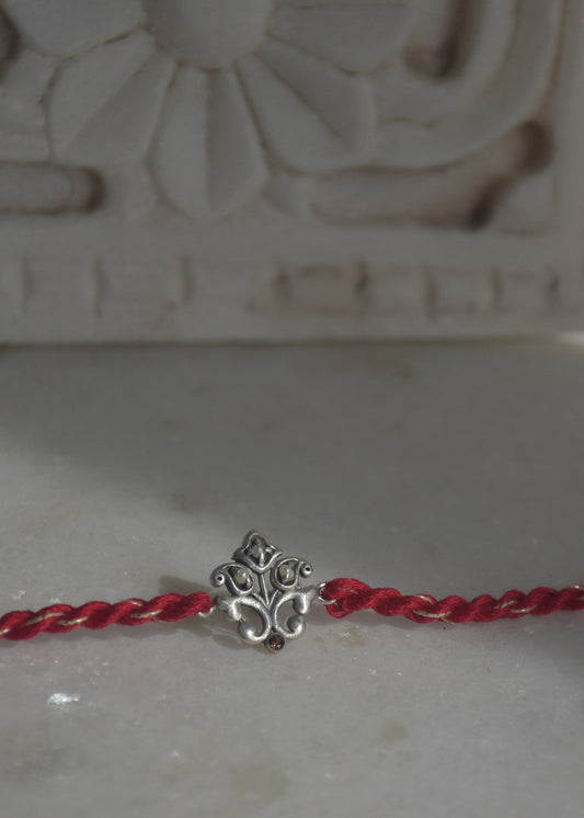  92.5 sterling silver Rakhi featuring real freshwater pearls and cotton thread.