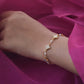 Kasturi Bracelet crafted in 925 silver with 18k gold plating, featuring intricate 4-petal floral motifs and accented with lustrous freshwater pearls. 