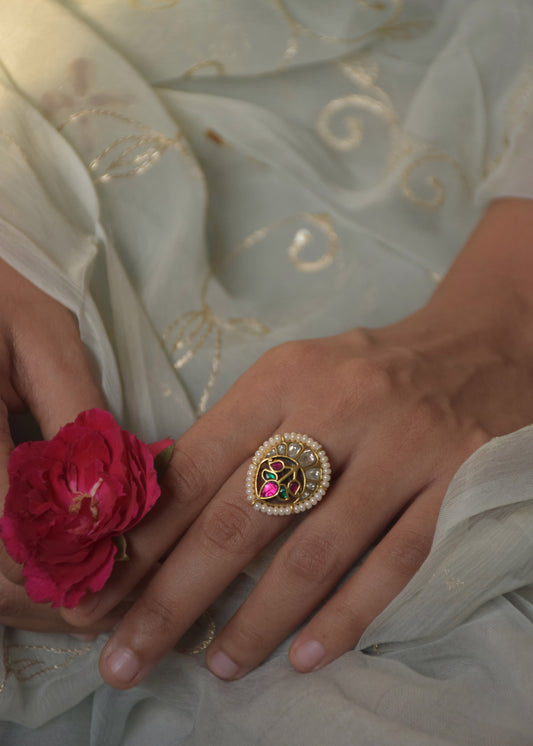Pankhudi Ring handcrafted in 925 silver with 22-carat gold plating, featuring a central petal motif adorned with multicolored Jadau stones and bordered with delicate seed pearls.