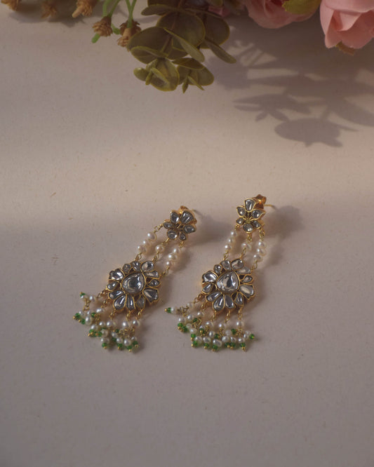 Jadau Pearl Drop Earrings crafted in 925 sterling silver featuring a flower-shaped top studded with jadau stones and an intricate jadau stone-studded motif suspended from three strands of pearls.