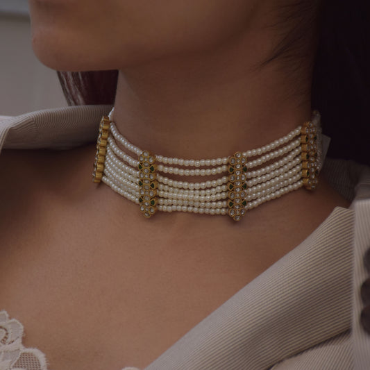 Raatrani Choker crafted in 925 silver featuring five vertical units with Jadau stone-studded flower motifs and seven strands of lustrous shell pearls.