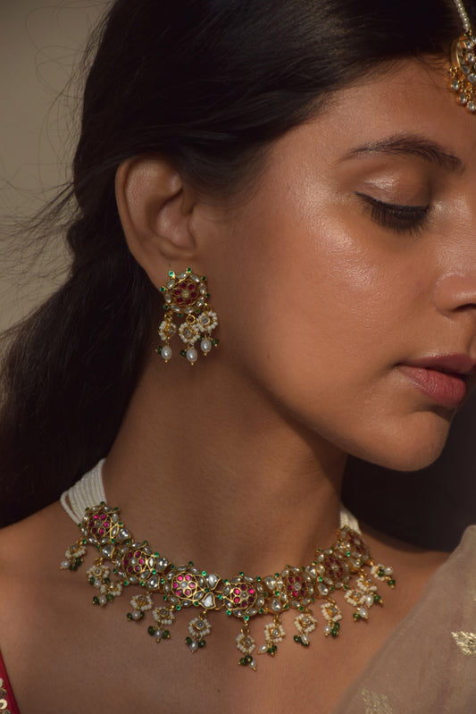  925 Silver, these earrings showcase a round floral motif adorned with Jadau stones and a dangling array of pearls.