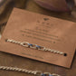 Sterling silver rakhi with blue enamel detailing on a brown card with 'NUVI' branding and text