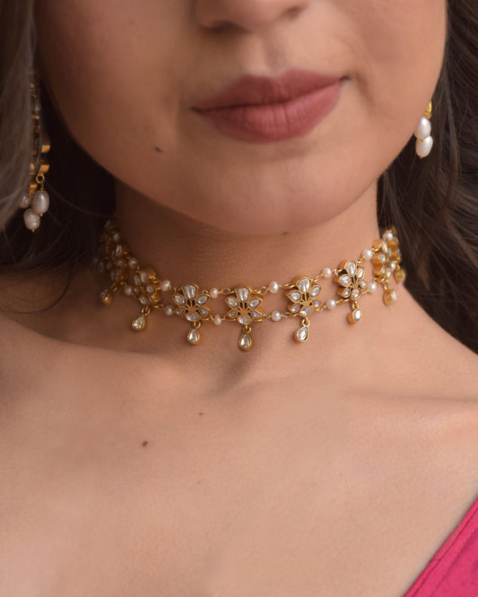 Deewani Choker Necklace crafted in 925 silver with gold polish, featuring delicate floral motifs adorned with shimmering jadau stones and linked with lustrous freshwater pearls.