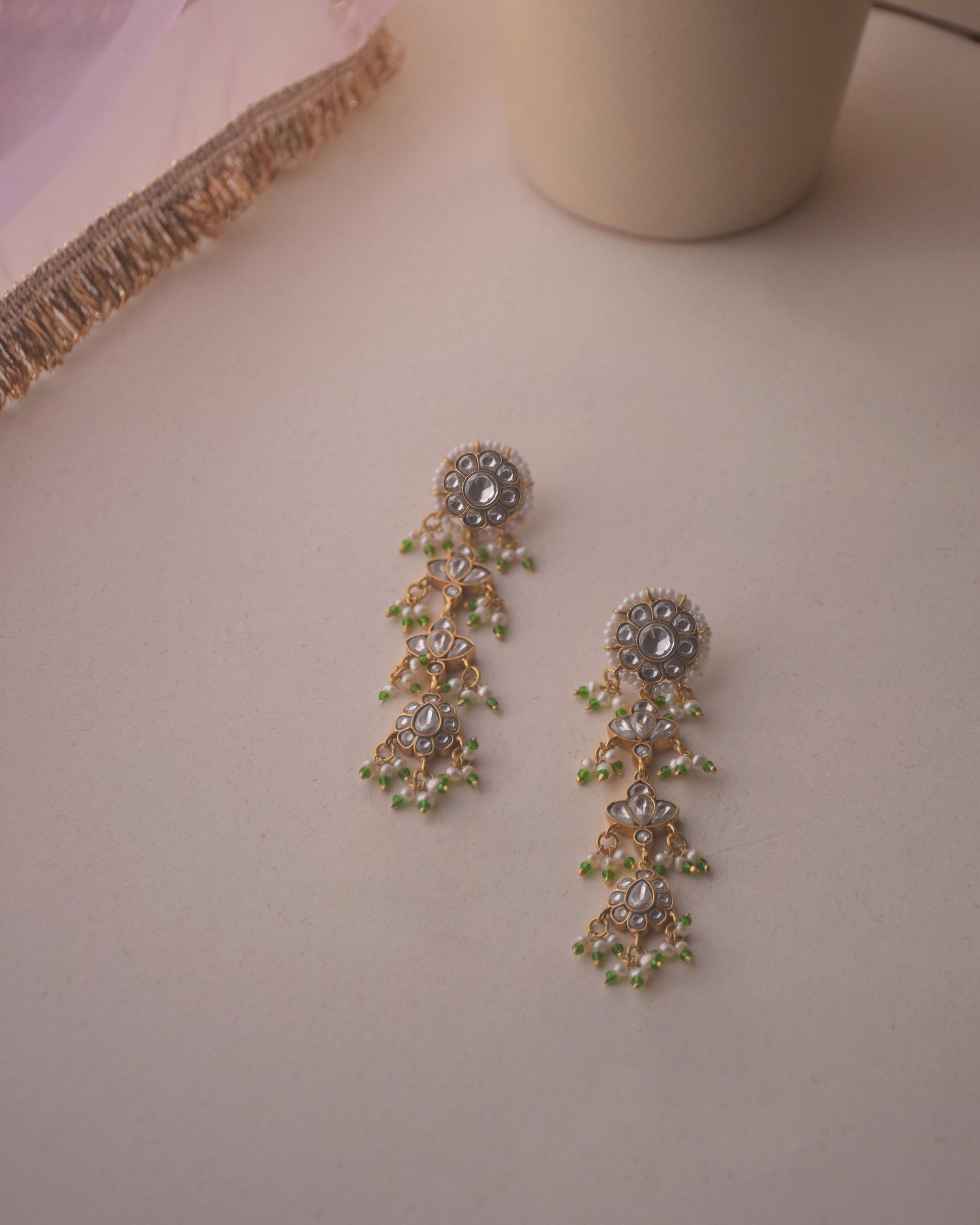 Dhanak Earrings crafted in 925 sterling silver featuring a round stud with four elegantly suspended units adorned with delicate hanging pearls.