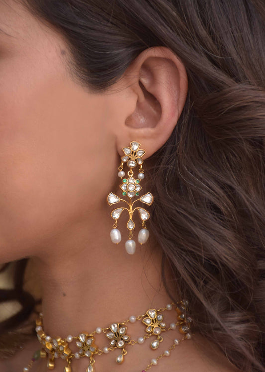 Matwaari Earrings crafted in 925 silver with gold polish, featuring a chandelier design with a stud embellished in white Jadau polkis and cascading rice pearls.