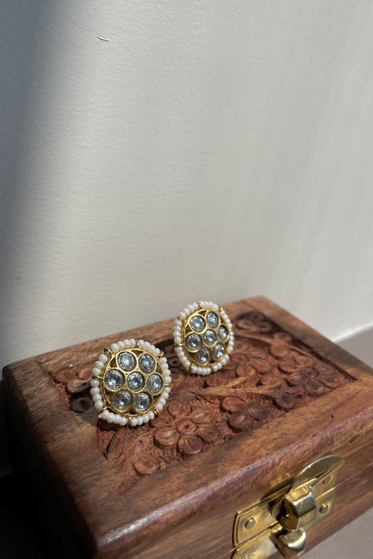 Mogra Jadau Earstuds in 925 silver with gold polish, featuring a floral design of seven round jadau stones and a seed pearl border.
