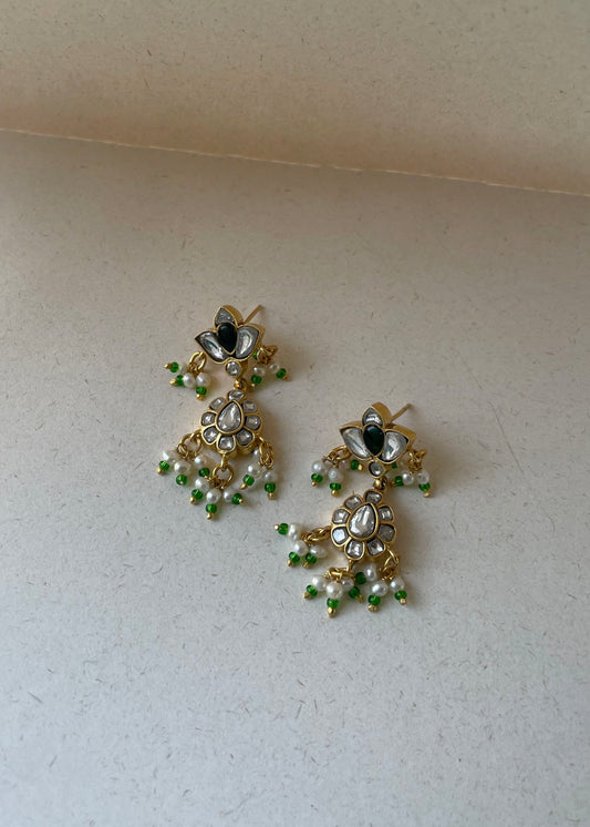 Nadiya Earrings crafted in 925 sterling silver featuring delicate floral units adorned with stunning jadau stones and strings of pearls.