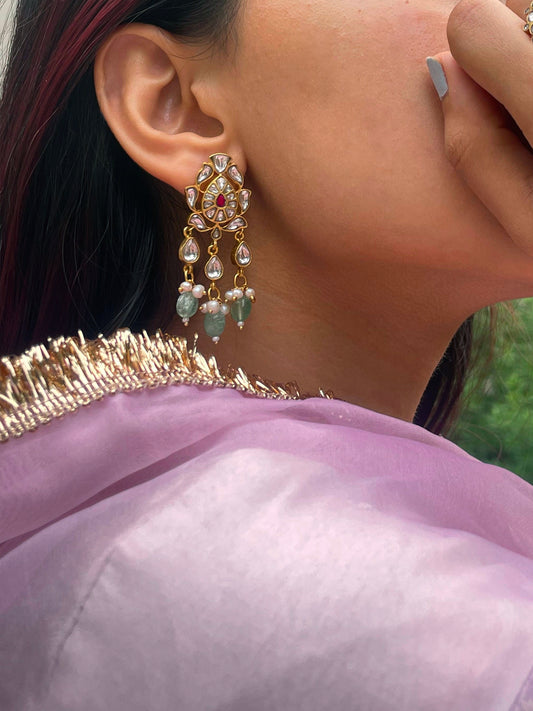  925 silver Nagma Phulkari Earrings, a celebration of vintage charm. Featuring a classic petal-shaped jadau motif adorned with multicolored jadau stones and accented by drop-shaped jadau units.