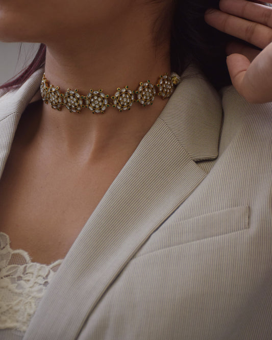 Rewati Choker crafted in 925 silver with 22k gold plating, featuring nine round units embellished with white Jadau stones.