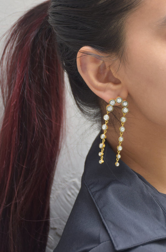 Tarangini Earrings crafted in 925 silver, featuring a flowing chain of Jadau stone collets that sway gracefully with every step.