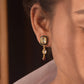 A striking Polki stone, adorned with deep black meena, with a dangling drop shape polki crafted in 92.5 Silver. 