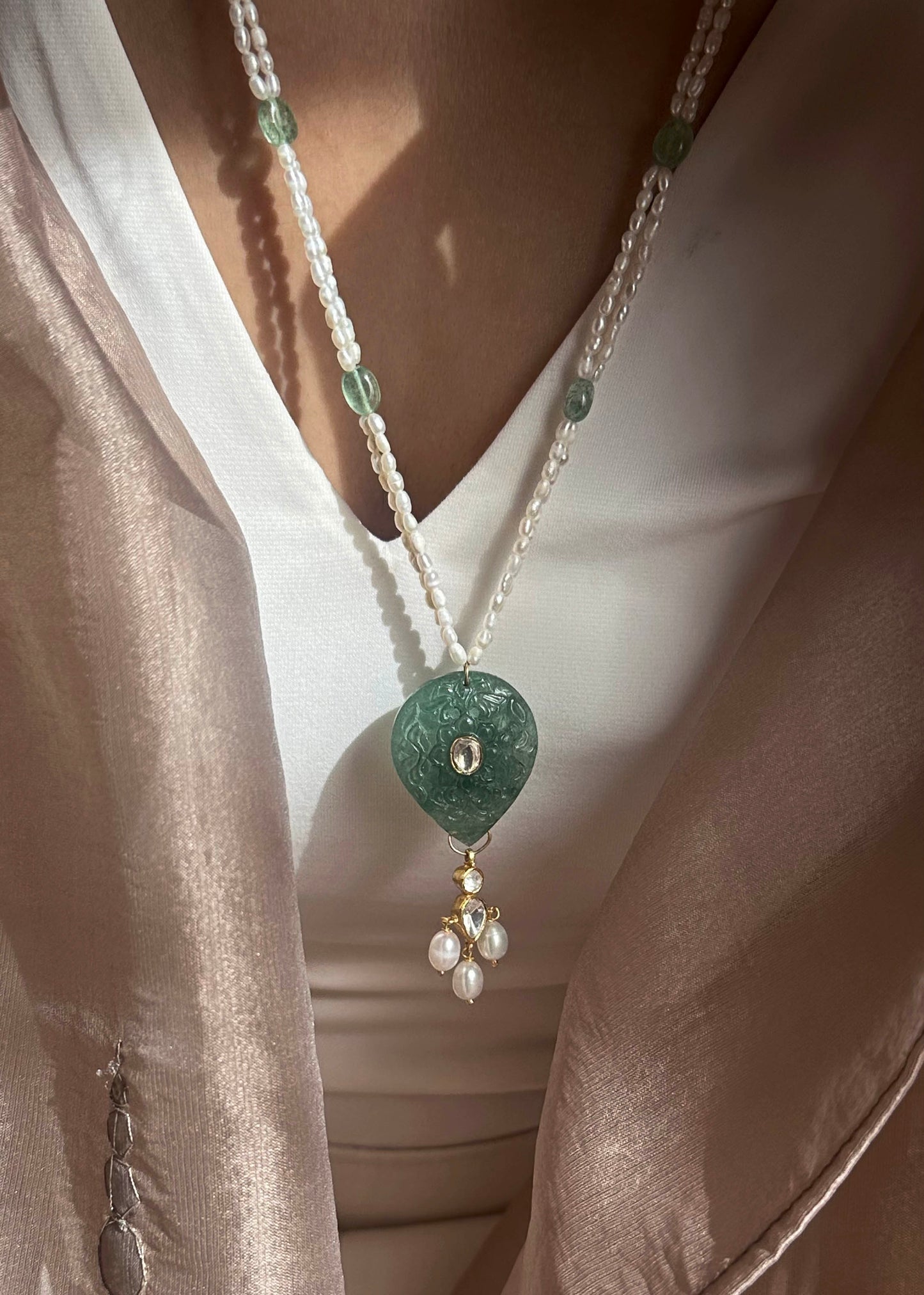 Navya long necklace handcrafted in 925 silver featuring a hand-carved green quartz pendant with polki detailing, elegantly strung on a freshwater rice pearl mala.