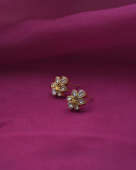 All-white Jadau floral stud earrings crafted from gold-polished 925 silver.