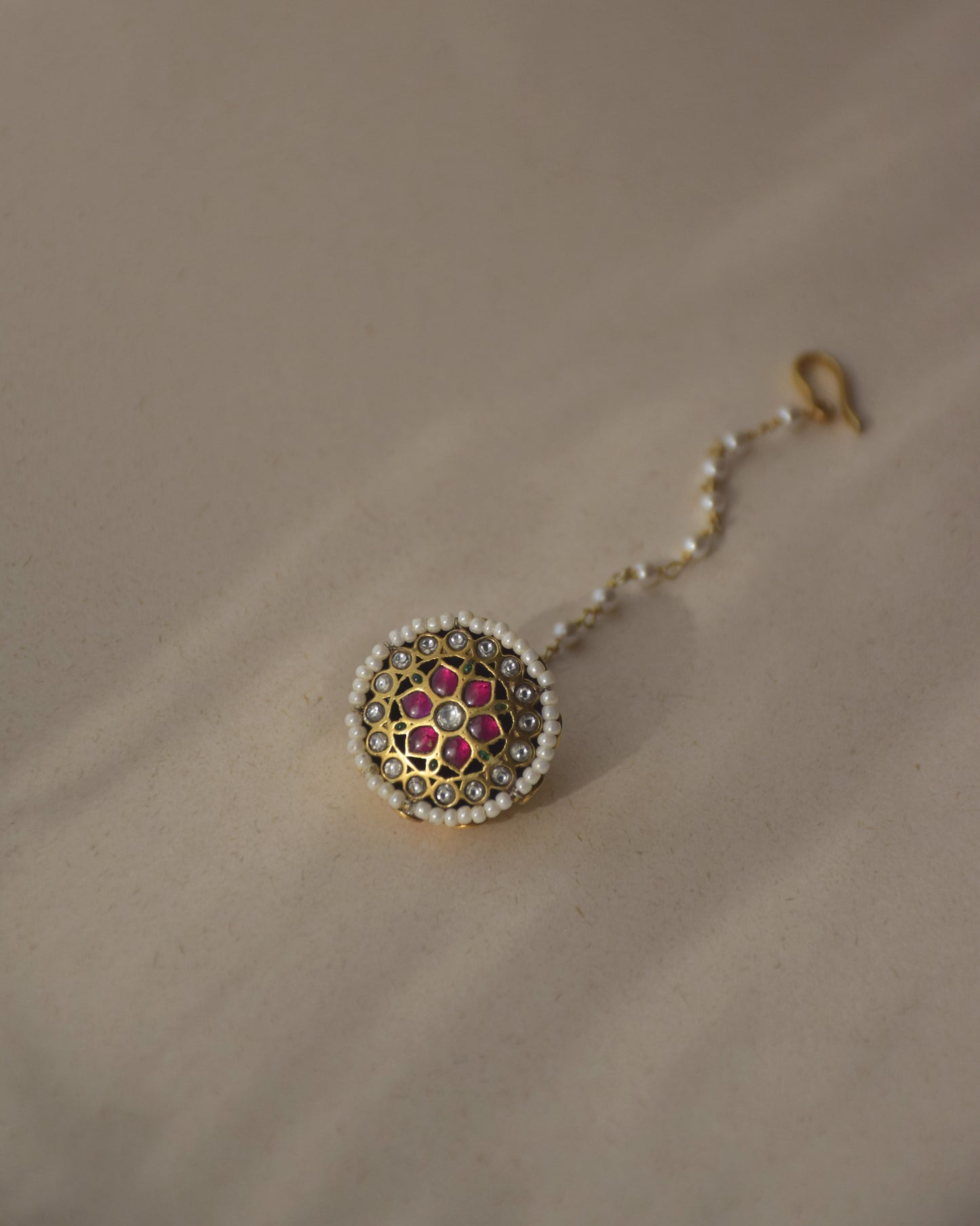 Aneri Borla handcrafted in 92.5 sterling silver featuring vibrant Jadau stones and a delicate line of seed pearls.
