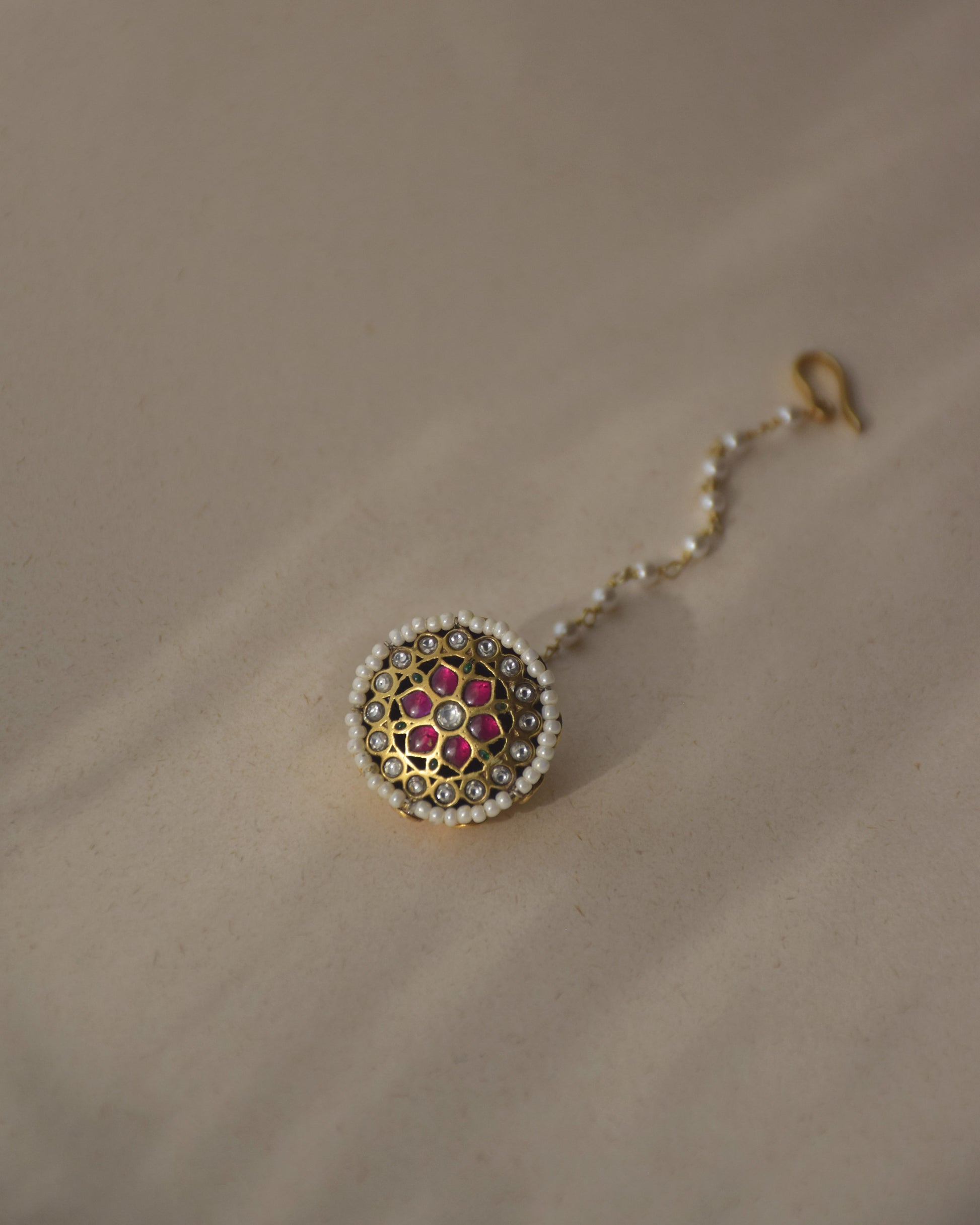 Aneri Borla handcrafted in 92.5 sterling silver featuring vibrant Jadau stones and a delicate line of seed pearls.