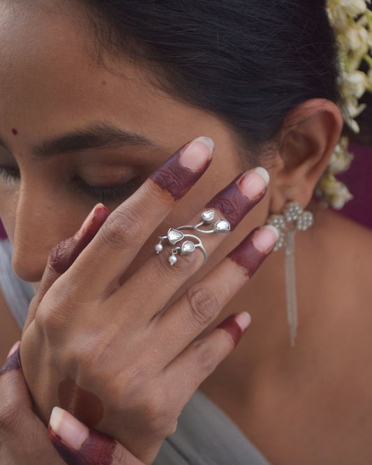 Anura mid-finger ring in 92.5 sterling silver featuring intricate floral motifs and adjustable design.