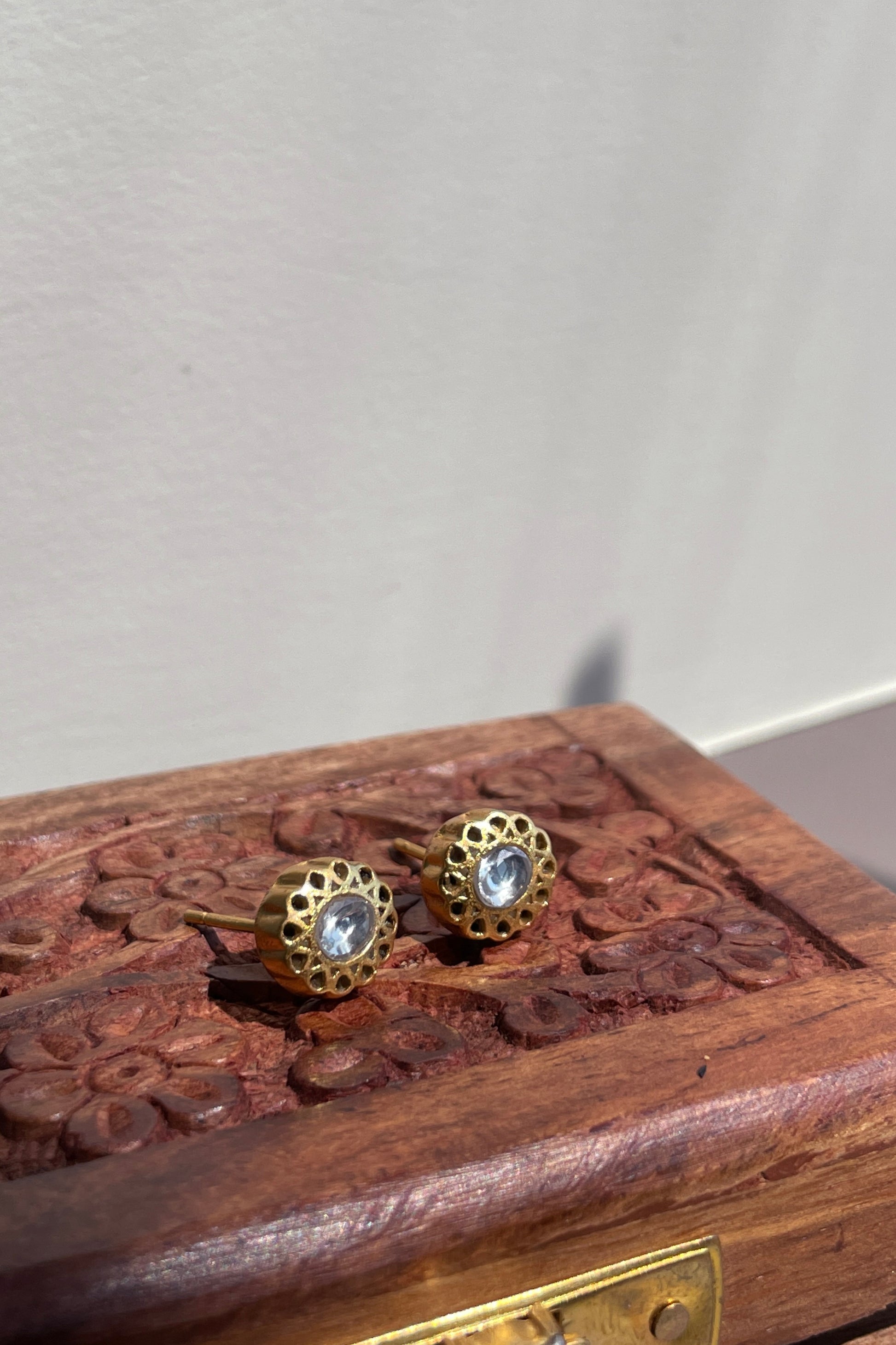 Bindiya 925 silver earstuds with radiant gold finish, featuring a single white Jadau stone and intricate gold wirework.