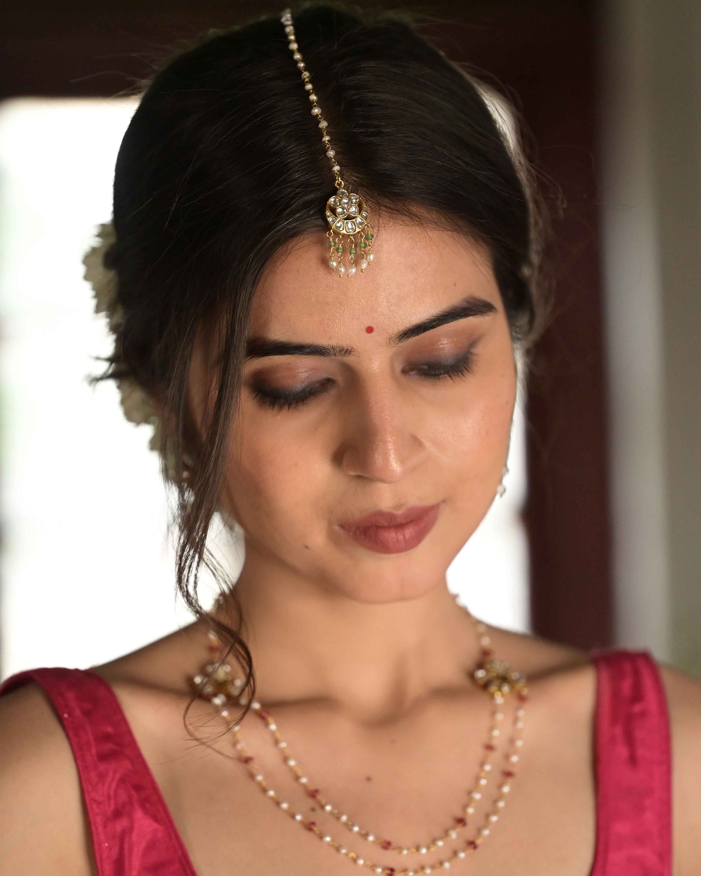 Traditional Suratiya Maangtika crafted in 925 silver, showcasing a timeless chaand design with delicate rice pearls and green aventurine accents.Latest Designer Silver Jewellery Online in India
