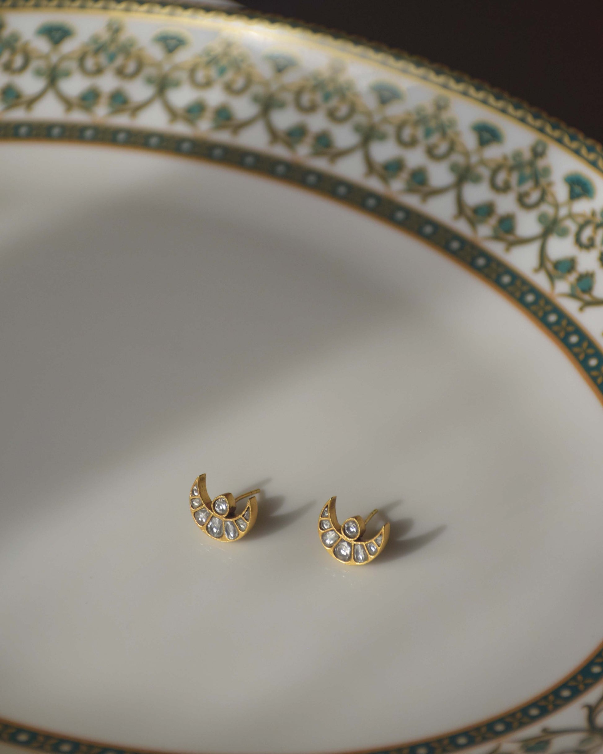 Chand earstuds crafted in 925 silver with 22-karat gold polish, featuring a minimalistic design with Jadau chand adorned with pristine white Jadau stones.